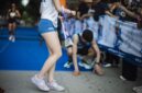 Runners cross the finish line at a marathon event in a city park. Participants rejoice and celebrate their achievements while others show signs of fatigue after the race.